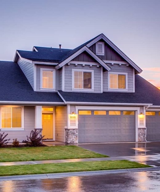 A suburban home at dusk with the garage door closed