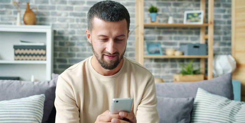 A homeowner searching for a roofing contractor on a smartphone at home