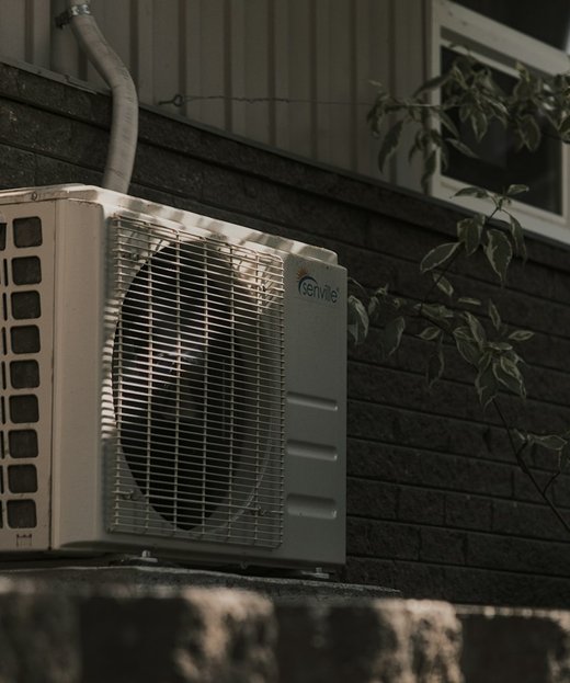 An air conditioning condenser unit mounted on an exterior wall