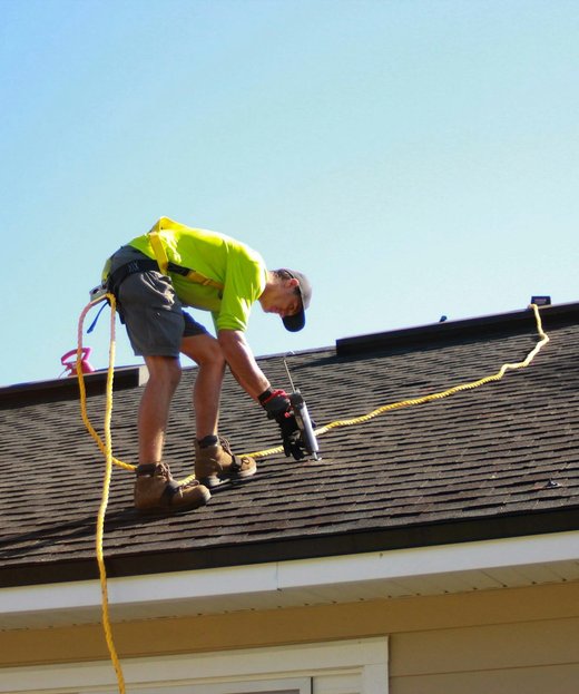 A roofing contractor working on a pitched roof