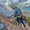 A roofing contractor installing shingles on a residential roof in a Texas neighborhood